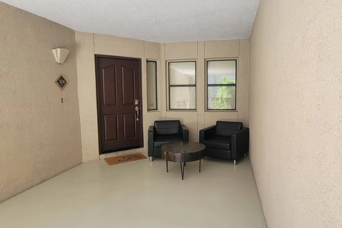 The photo shows the condo’s entrance area, featuring the front door, a round table, and black chairs. The space feels welcoming and is perfect for gathering as a family before or after local outings, suggesting the comfort of returning 'home' after a day of adventure.